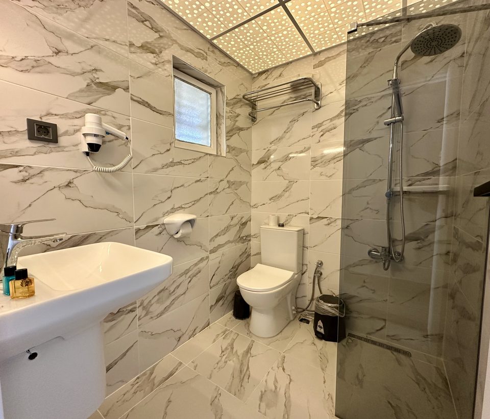 Lavabo, tuvalet ve duş kabininin geniş görünümü.