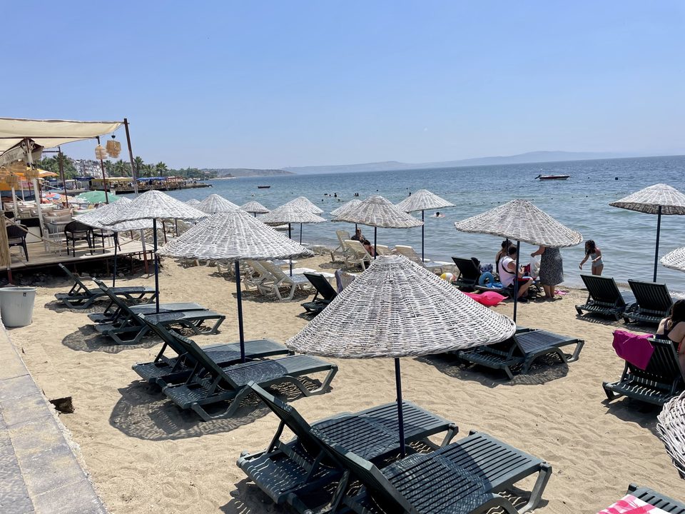 Deniz kıyısında şemsiyeler ve şezlonglar.