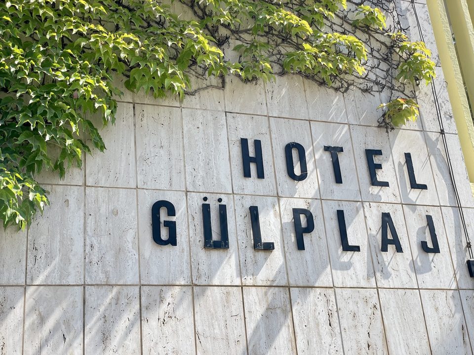 Sarmaşıklar arasındaki Hotel Gülplaj tabelası.