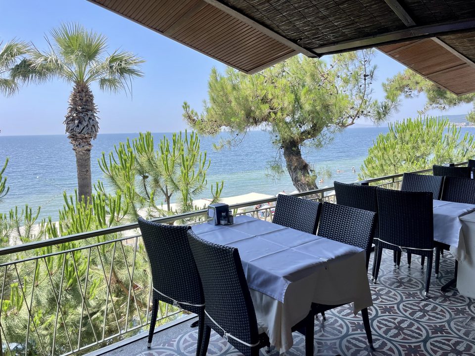 Denize bakan restoran terasında hazırlanmış masalar.