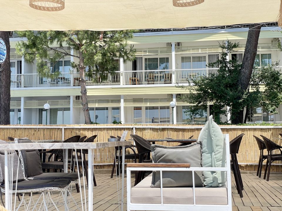 Teras oturma alanından balkonlu otel cephesi.
