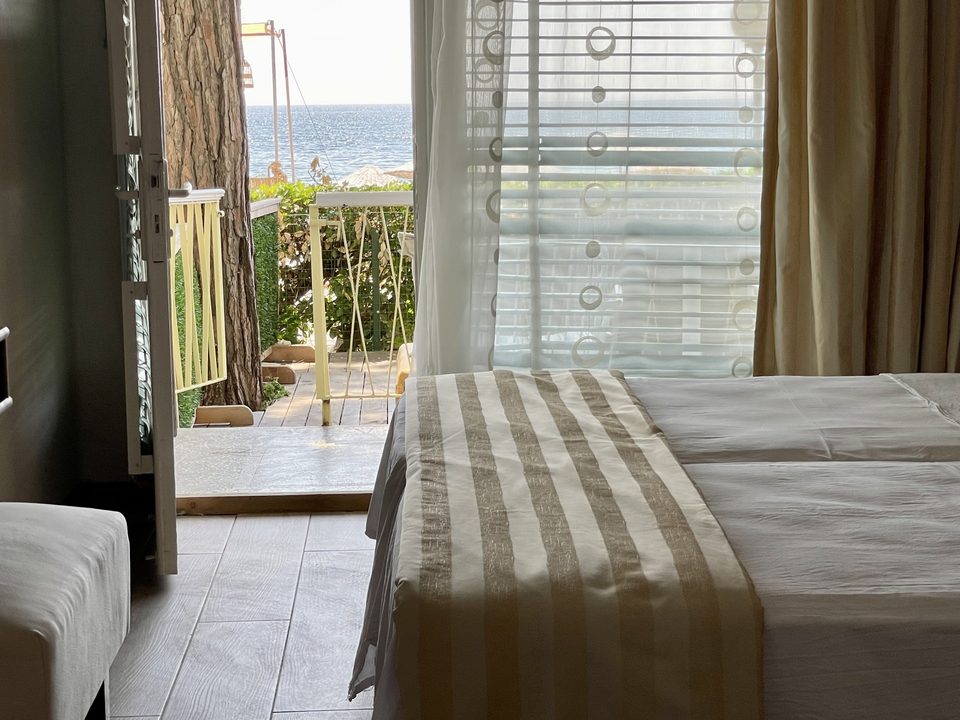 Balkon kapısı ve deniz manzarası yönündeki oda görünümü.